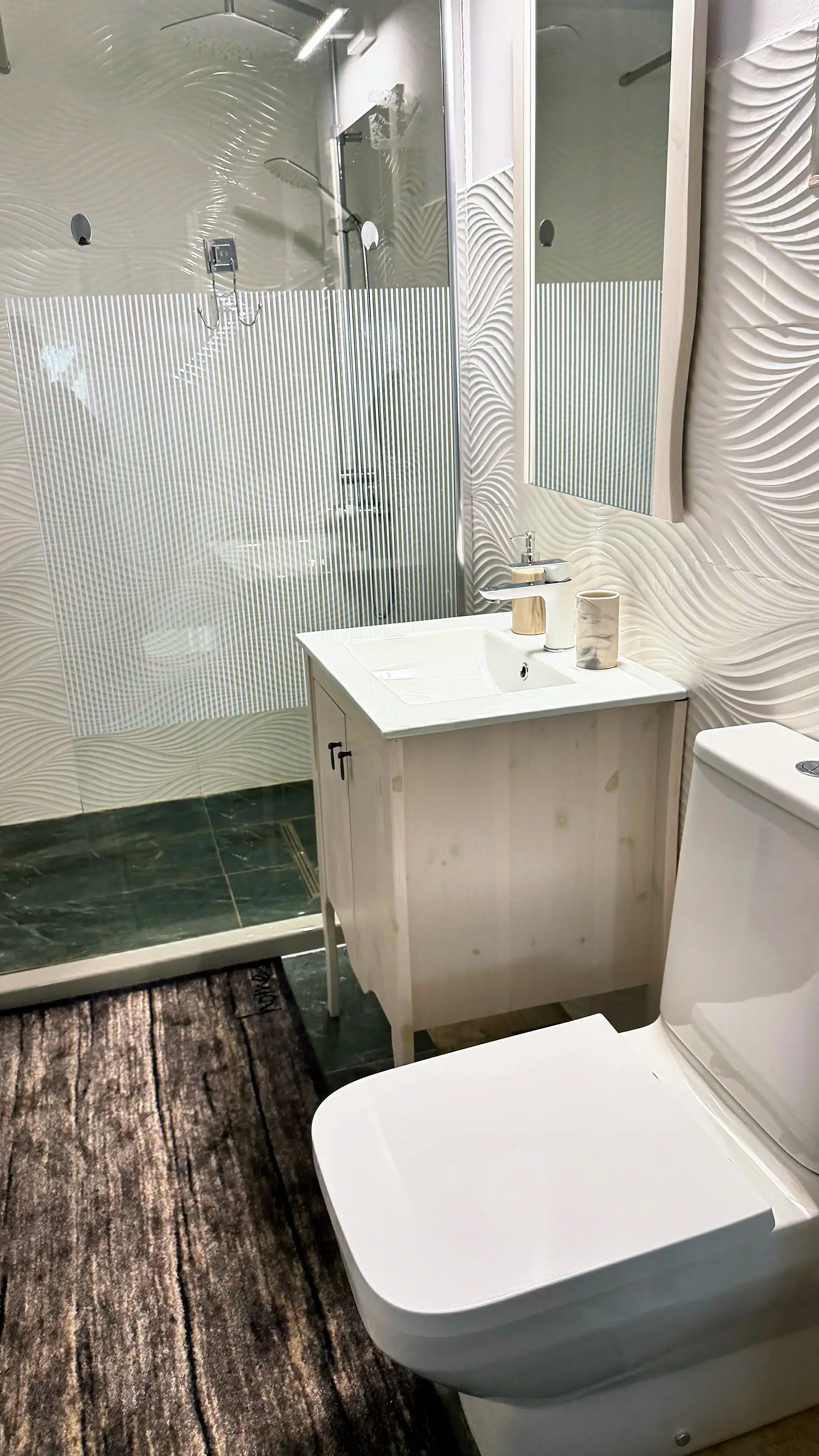 A modern bathroom with a walk-in shower and a washbasin