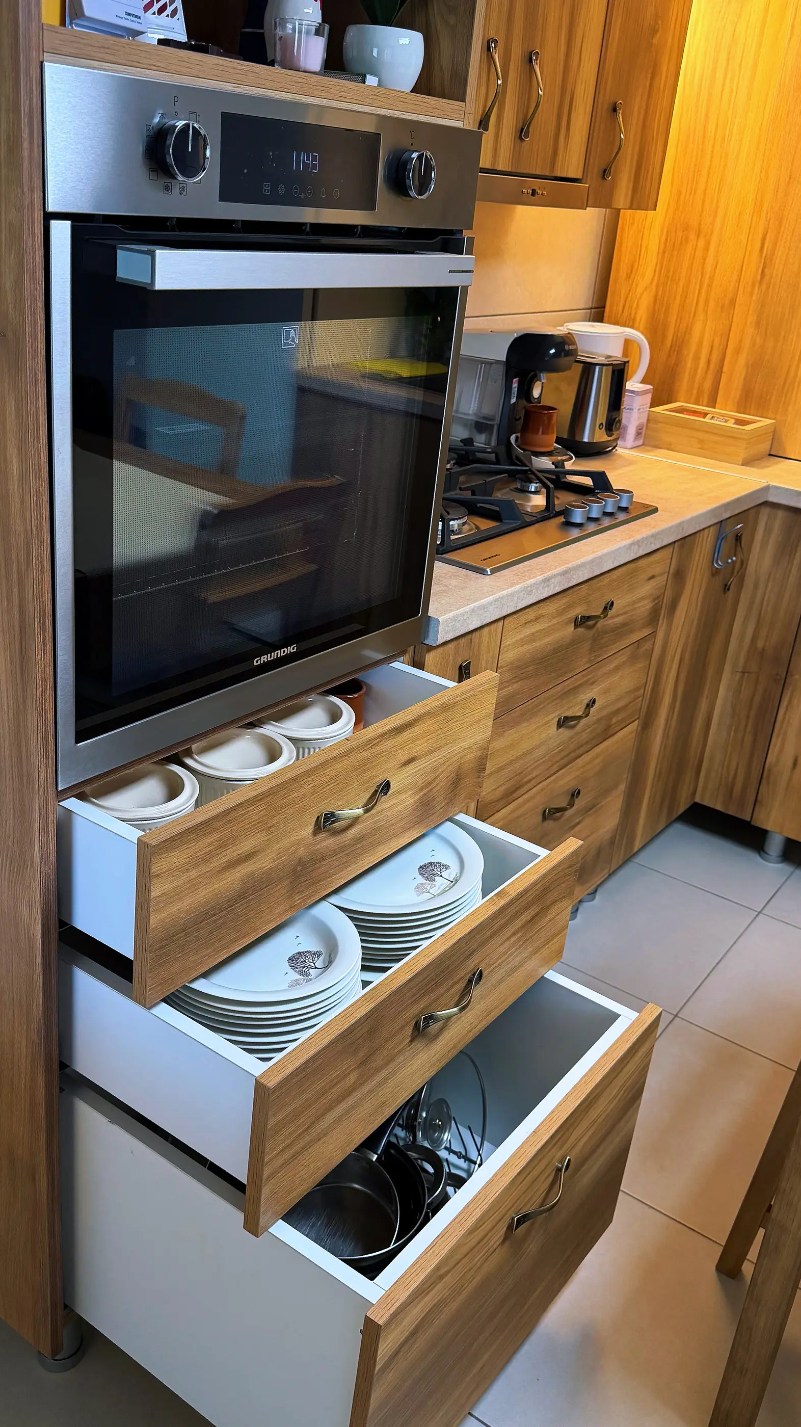 Cuptor electric și sertare cu veselă în bucătărie