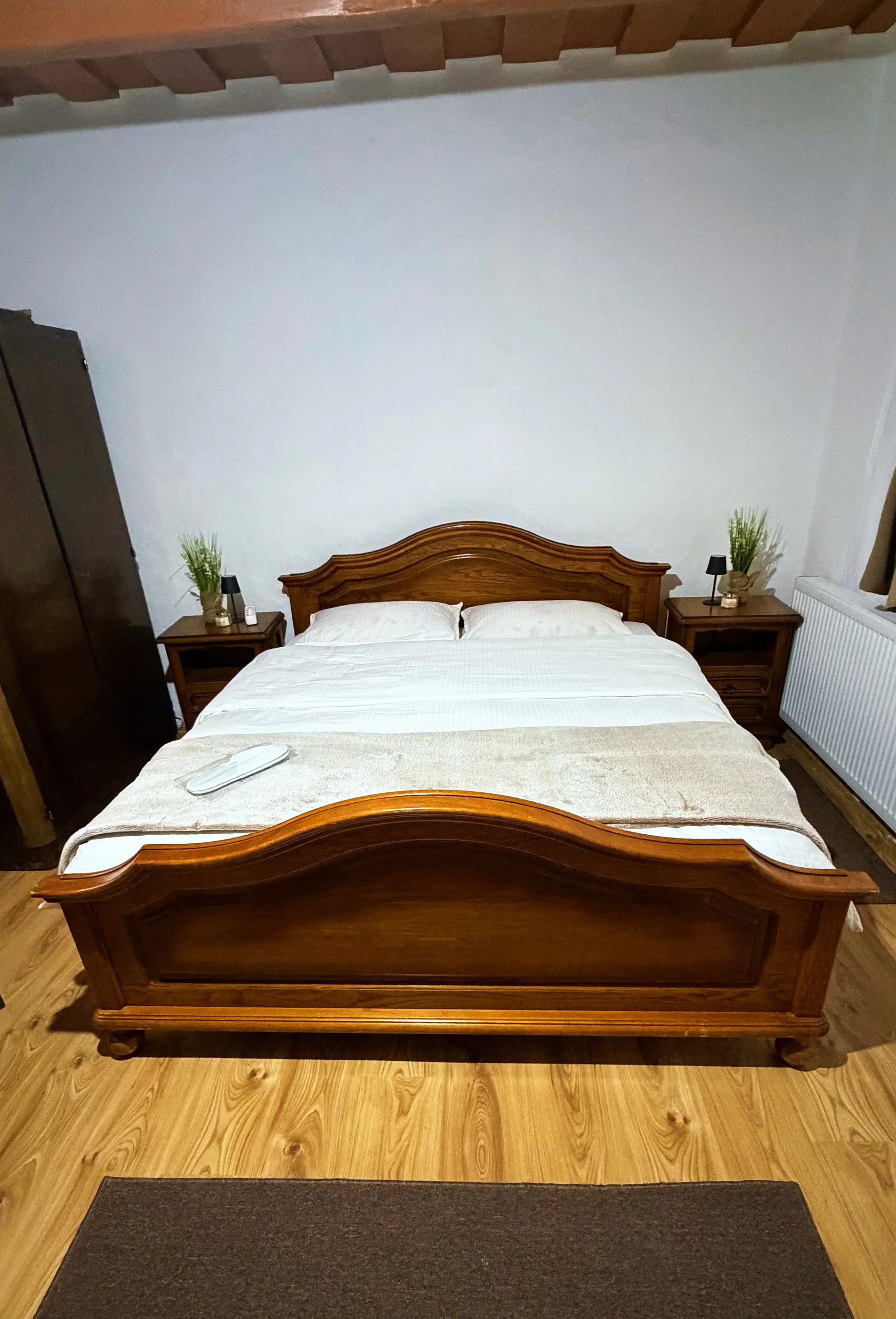 Bedroom with a carved wooden double bed and bedside tables