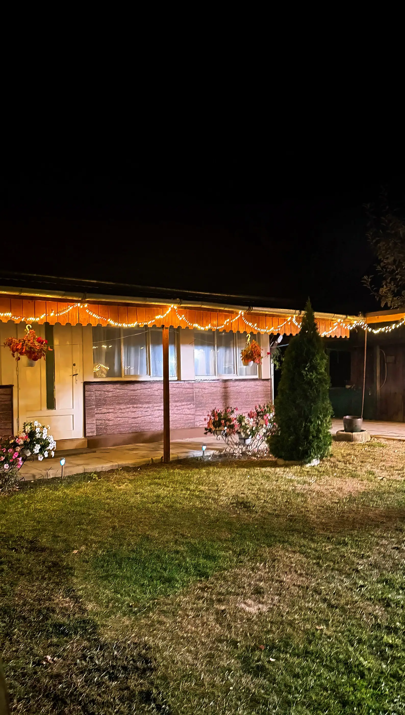 Casa Steluța at night, with the fairy lights on under the eaves