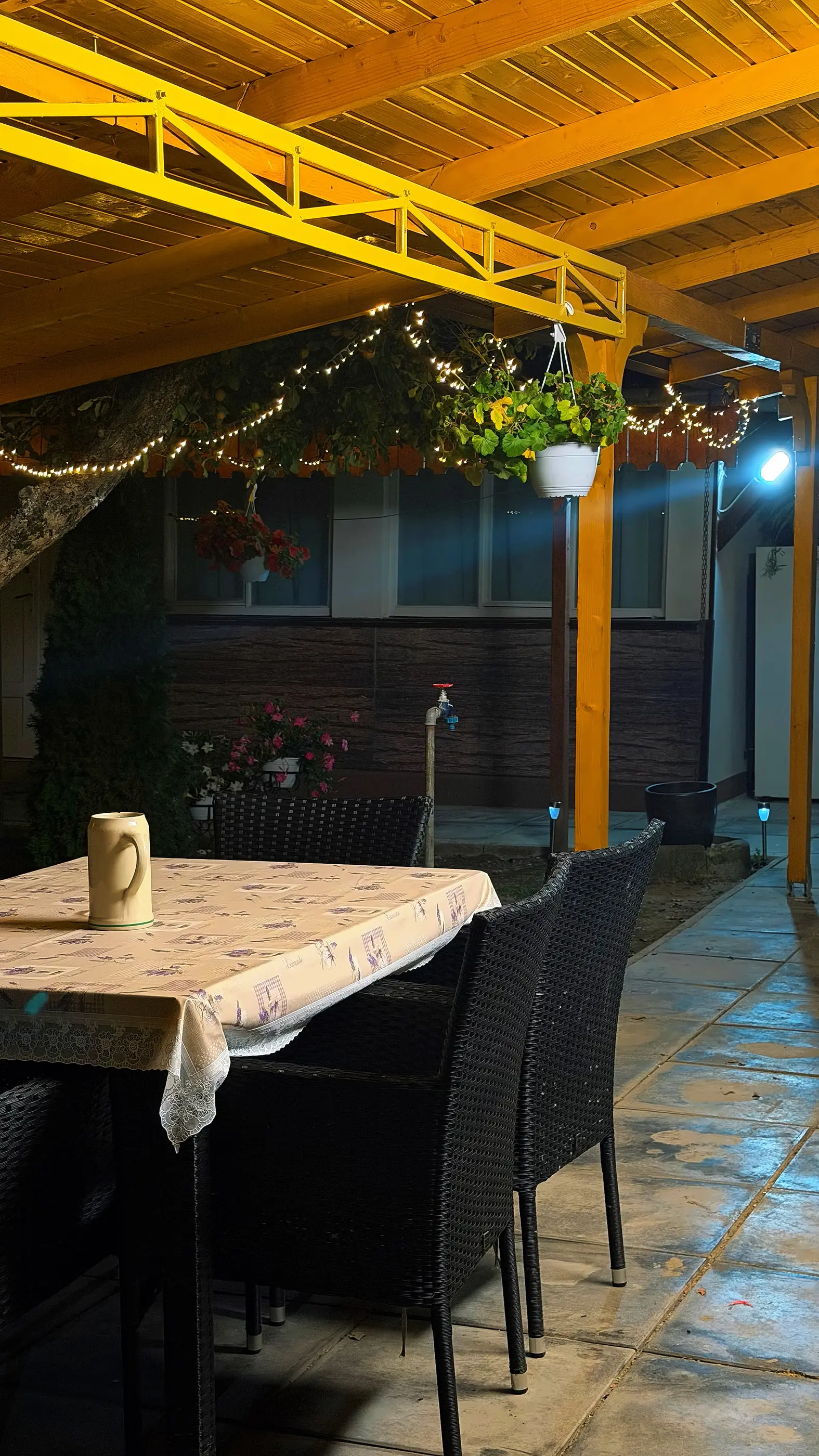 The terrace table at night, under fairy lights and flowers