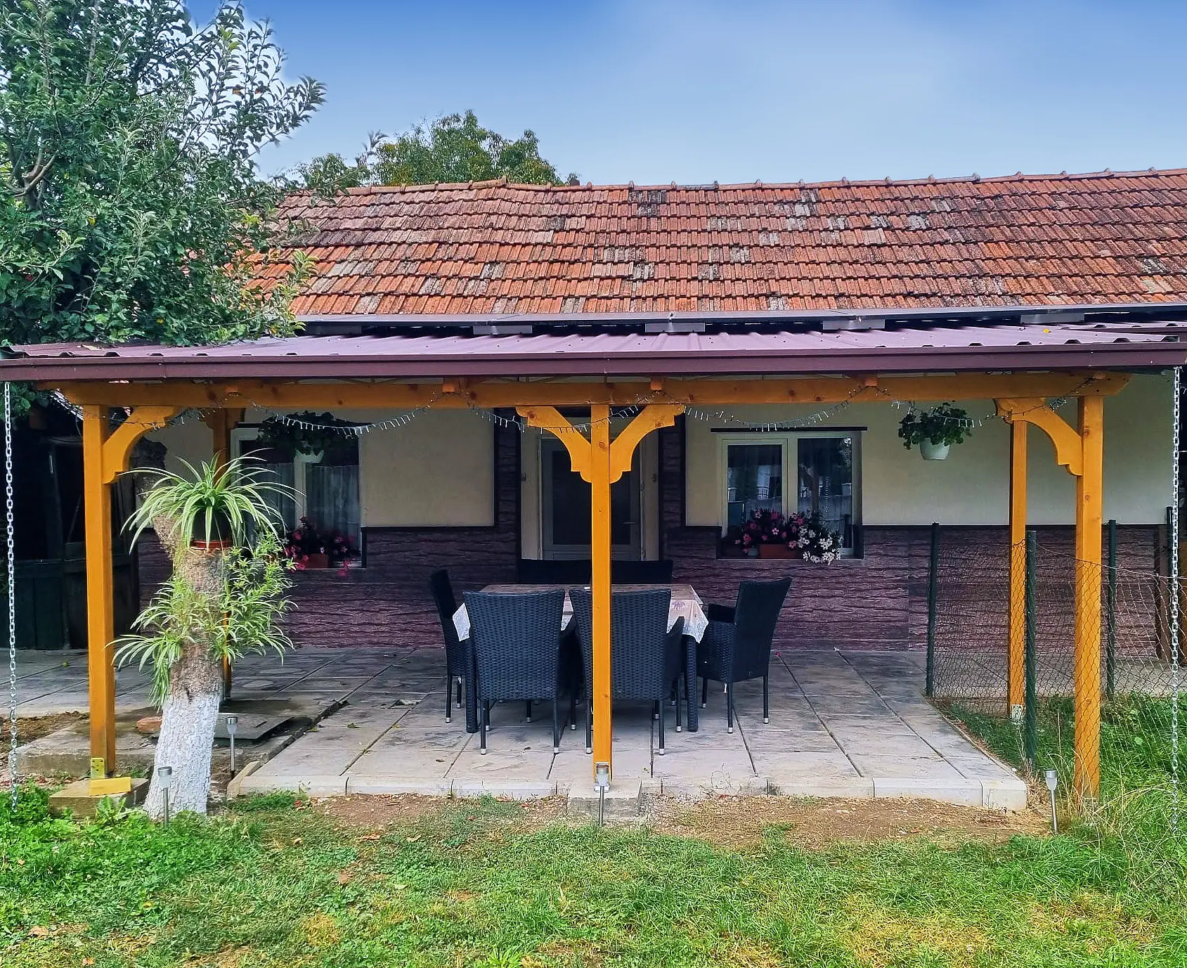 The covered terrace with a wooden pergola and a table for six